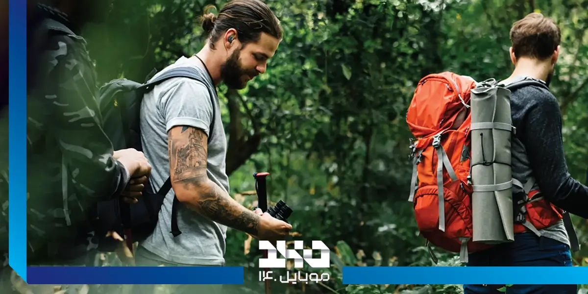 هندزفری بی‌سیم گرین لاین مدل Enduro در گوش آقایی در جنگل
